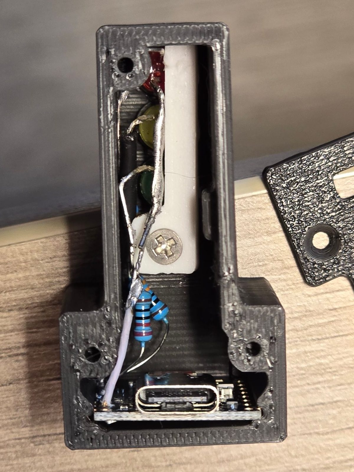 Retainer 05 installed from the rear and secured with its lower screw; the LED leads and resistors stay clear of it